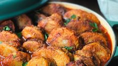 a pan filled with meat and sauce on top of a table