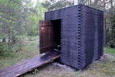 an outhouse in the woods with a ramp leading to it