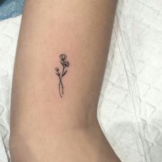 a small flower tattoo on the left side of the arm, with an instagram message below it