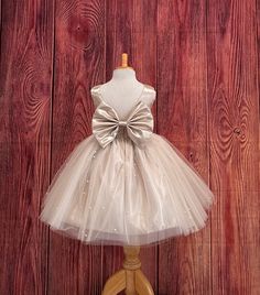 Our enchanting Knee Length flower girl dresses are sure to turn heads! This beautiful elegant sophisticated dress is handmade, the bodice consists of Champagne Bridal Satin with a sowed in sash at the waist, the back of the dress consists of an open V-back with a hidden zipper. The big bow is detachable. The skirt consists of 4 layers of tulle with the top layer consisting with sowed in pearl beads. The fifth layer is made of lining with crinoline for fullness.  This dress is perfect for any occasion!  Dress Is Pictured with a petticoat NOT INCLUDED https://www.etsy.com/listing/1316417982/white-knee-length-petticoat-wedding?click_key=41cb8b0ae4587efa582b0a433f3f5e0cde12aec0%3A1316417982&click_sum=af1df37b&ref=shop_home_active_1 Visit our store, more items to come!  https://www.etsy.com/sho Brown Wedding Dress, Princess Photoshoot, Pageant Girls, Toddler Flower Girl Dresses, Girls Pageant Dresses, Brown Wedding, Evening Makeup, Princess Ball Gowns, Elegant Sophisticated