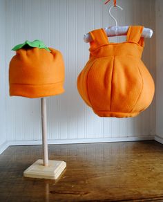 two stuffed oranges hanging from clothes pins