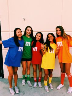 four girls in matching outfits posing for the camera