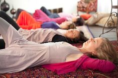 two women are laying on the floor with their legs crossed