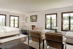 a living room filled with furniture and windows next to a fire place in a bedroom