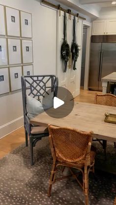 a dining room table with chairs and pictures on the wall behind it in an open kitchen