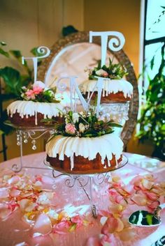 three tiered cake sitting on top of a table covered in pink and white frosting