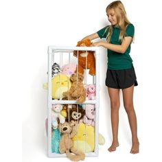 a woman is holding onto a rack with stuffed animals in it and she is leaning against the wall