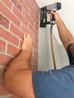 a man is using a drill to fix a brick wall with a power driller