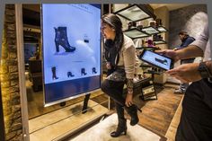 a woman standing in front of a display with shoes on it