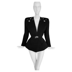 Iconic Thierry Mugler FW 1990 jacket. Similar version of this was worn by Naomi Campbell on the Runway Show. Extremely rare Collectors piece, a true Thierry Mugler Statement jacket. Stunning fitted black jacket with silver metal Mugler star details on the front bodice and also on the back. Fabulous big silver metal Thierry Mugler brooch at the waist. Beautiful mugleresque feminine sculptural shape, fitted waist, deep V-neck, this is extraordinairy architectual tailoring. Closes with press button Mugler Coat, Thierry Mugler Bug, Thierry Mugler Celebrities, Mugler Jackets Tailoring, Thierry Mugler Leather Jacket, Statement Jacket, Thierry Mugler, Naomi Campbell, Black Jacket