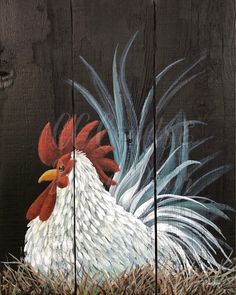 a rooster painted on the side of a wooden fence with grass in front of it