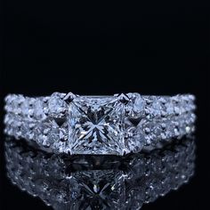 a fancy diamond ring on top of a reflective surface