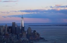 the empire building towering over the city of new york, ny at sunset with clouds in the sky