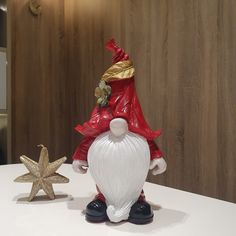 a santa clause figurine sitting next to a star on a white counter top