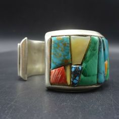 "VINTAGE ANDREW ALVAREZ BRACELET DESCRIPTION: This outstanding cuff is from celebrated artisan Andrew Alvarez. Extremely heavy gauge sterling silver is adorned with cobblestone inlay of turquoise, malachite, spiny oyster shell, and mother of pearl. This exquisite bracelet will be a cherished addition to your collection of fine vintage Southwest and Native American jewelry. MEASUREMENTS: Interior of the cuff measures 5 1/2\" with an additional 1 1/8\" non-adjustable gap. Total circumference: 6 5/ Artisan Gemstone Bracelets, Multicolor Adjustable Cuff Bracelet For Formal Occasions, Adjustable Multicolor Cuff Bracelet For Formal Occasions, Vintage Bangle Cuff Bracelet With Natural Stones, Vintage Cuff Bracelet With Natural Stones, Unique Multi-stone Cuff Bracelet Gift, Vintage Gemstone Cuff Bracelet Bangle, Multicolor Handmade Cuff Bracelet Collectible, Unique Multi-stone Cuff Bracelet As A Gift