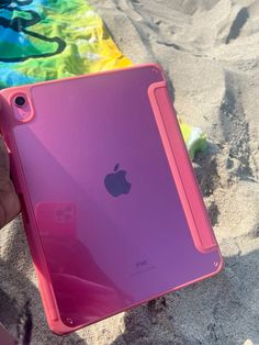 a person holding an ipad in the sand