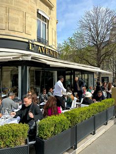 many people are sitting at tables outside the restaurant