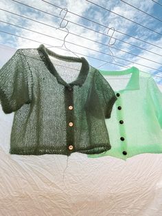 two sweaters hanging on clothesline with blue sky in the background