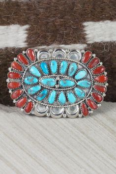 This Sleeping Beauty turquoise, coral and sterling silver squash blossom, concho belt, earrings, pin/ pendant, bracelets, and rings set was made by Navajo silversmith Justina Wilson. The back is signed JW and stamped sterling.Squash BlossomLength: 26 1/2"Naja Height: 3"Naja Width: 3"Blossom Length: 1 1/8"Blossom Width: 2 1/8" Concho Belt Belt Length: up to 60" Belt Buckle Length: 3 1/4" Belt Buckle Width: 2 1/8" Concho Length: 2 1/2" Concho Width: 1 3/4" EarringsLength: 1 1/2"Width: 1 1/8"Pin/ P Western Style Oval Concho Jewelry, Traditional Concho Jewelry For Western-themed Events, Western Style Concho Jewelry Collectible, Artisan Jewelry With Concho For Western-themed Events, Southwestern Concho Jewelry For Western-themed Events, Southwestern Style Concho Jewelry For Western-themed Events, Silver Squash Blossom Necklace, Bracelets And Rings, Concho Belt