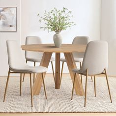 a dining table with four chairs and a vase on the table in front of it