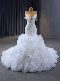 a white wedding dress on display in a room