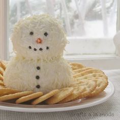 a white plate topped with crackers and a snowman made out of rice krispy kreme