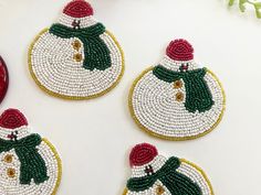 three beaded snowman ornaments sitting on top of a table