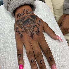 a woman with pink fingernails and tattoos on her hand