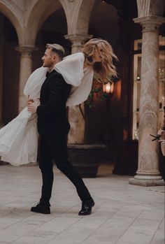 a man in a tuxedo carrying a woman on his back while she holds her