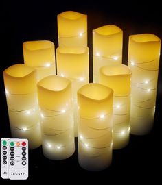 many lit candles are arranged in rows on a black surface