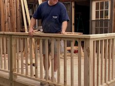 a man standing on top of a wooden deck next to a building under construction in the background