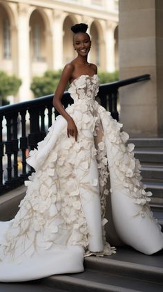 a woman in a white dress standing on some stairs