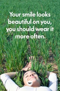 a woman laying in the grass with her eyes closed, smiling and looking up at the sky