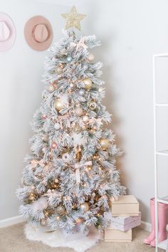 a white christmas tree with gold and silver ornaments in a girls'room decorated for christmas