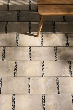 a wooden bench sitting on top of a tiled floor