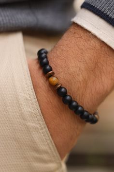 Matte Black Onyx with Matte Tiger Eye  Bracelet, Balance Bracelet, Mens Bracelet, Stretch Bracelet, Gemstone Bracelet, Healing Bracelet,Men gifts    Discover the powerful combination of Matte Black Onyx and Tiger Eye in our Men's Bracelet. This balance bracelet, crafted with gemstone healing properties, is the perfect gift for men. Matte Black Onyx is known for its grounding and protective qualities. It helps to absorb negative energy, promote emotional stability, and enhance self-control. Cube Tiger Eye, with its captivating golden-brown hues, is a stone of courage and strength. It promotes confidence, clarity, and a balanced approach to life. When these two gemstones are combined, they create a harmonious synergy. The Matte Black Onyx and Cube Tiger Eye Men's Bracelet not only adds a sty Tiger Eye Bracelet Men, Handmade Black Onyx Bracelets, Handmade Onyx Black Bracelets, Onyx Bracelets With Black Beads As Gift, Minimalist Onyx Bracelets As Gift, Adjustable Onyx Bracelet Gift, Minimalist Onyx Bracelets For Gift, Hand-strung Black Beaded Bangle Bracelet, Black Hand-strung Bracelets