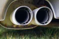 there are two exhaust pipes on the back of a car that is parked in the grass