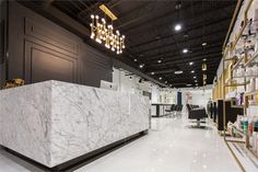 the interior of a hair salon with white marble counter tops and gold trimmings