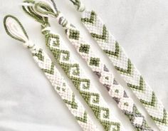 three green and white braided bracelets laying next to each other