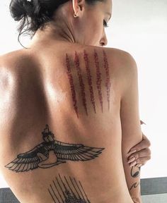 the back of a woman with tattoos on her chest