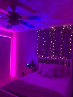 a bedroom with purple lighting and stars on the ceiling