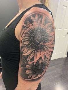 a woman's half sleeve with sunflowers on her left arm and shoulder