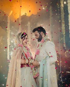 two people standing next to each other in front of confetti