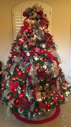 a christmas tree decorated with red, white and black bows