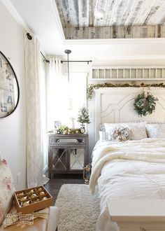 a white bed sitting in a bedroom next to a window