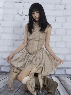 a woman sitting on top of a wooden floor next to a white brick wall and wearing knee high boots