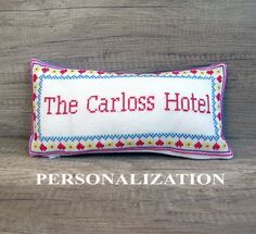 a cross stitch pillow that says the carols hotel on it's front and back