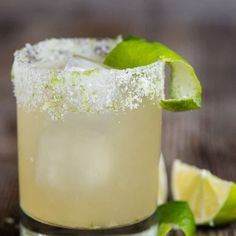 a margarita cocktail with limes and sugar on the rim