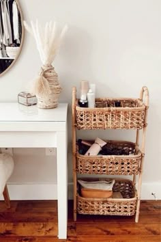 a white table with baskets on it next to a mirror and other items in the room