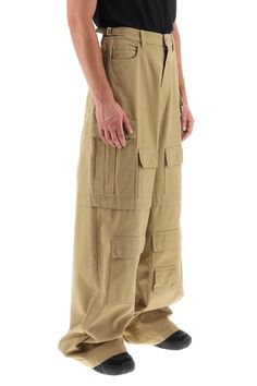 These Ambush wide-leg cargo pants are crafted of cotton basketweave and showcase a five-pocket style in addition to multiple flap pockets along both legs. Cut in a mid-rise, this piece is finished with adjustable side waist straps, belt loops and a zip fly with button fastening. The model is 187 cm tall and wears a size M. Size Info STANDARD Color Detail Beige Made In Italy Material 100%CO Season One spring Season Two summer Product clothing Brand Ambush Size And Fit Khaki Wide-leg Cargo Jeans, Utility Wide Leg Trousers With Multiple Pockets, Khaki Wide Leg Utility Pants, Military Style Baggy Wide Leg Cargo Pants, Cotton Combat Cargo Pants, Combat Style Cotton Cargo Pants, Cotton Combat Cargo Pants Full Length, Combat Style Wide Leg Pants With Multiple Pockets, Combat Style Wide-leg Pants With Multiple Pockets